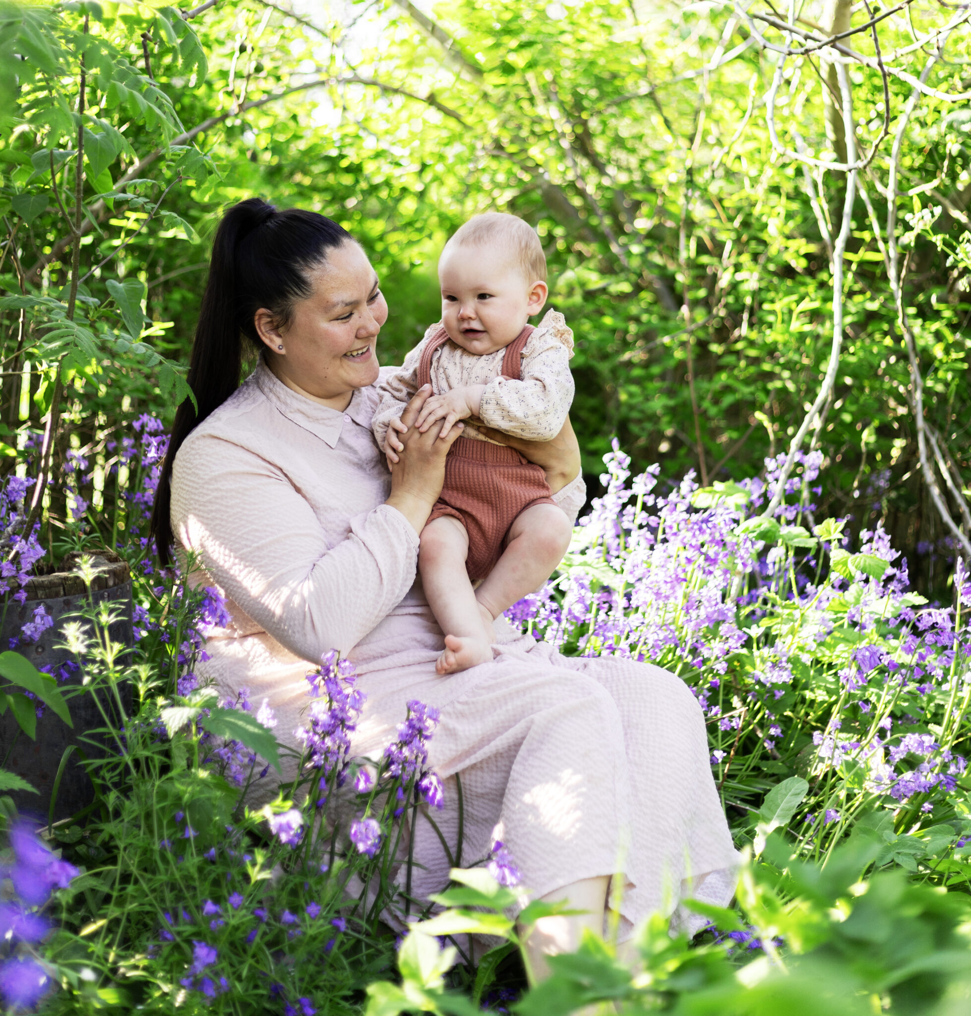 Portrætfoto af mor og datter ude i naturen omgivet af blomster